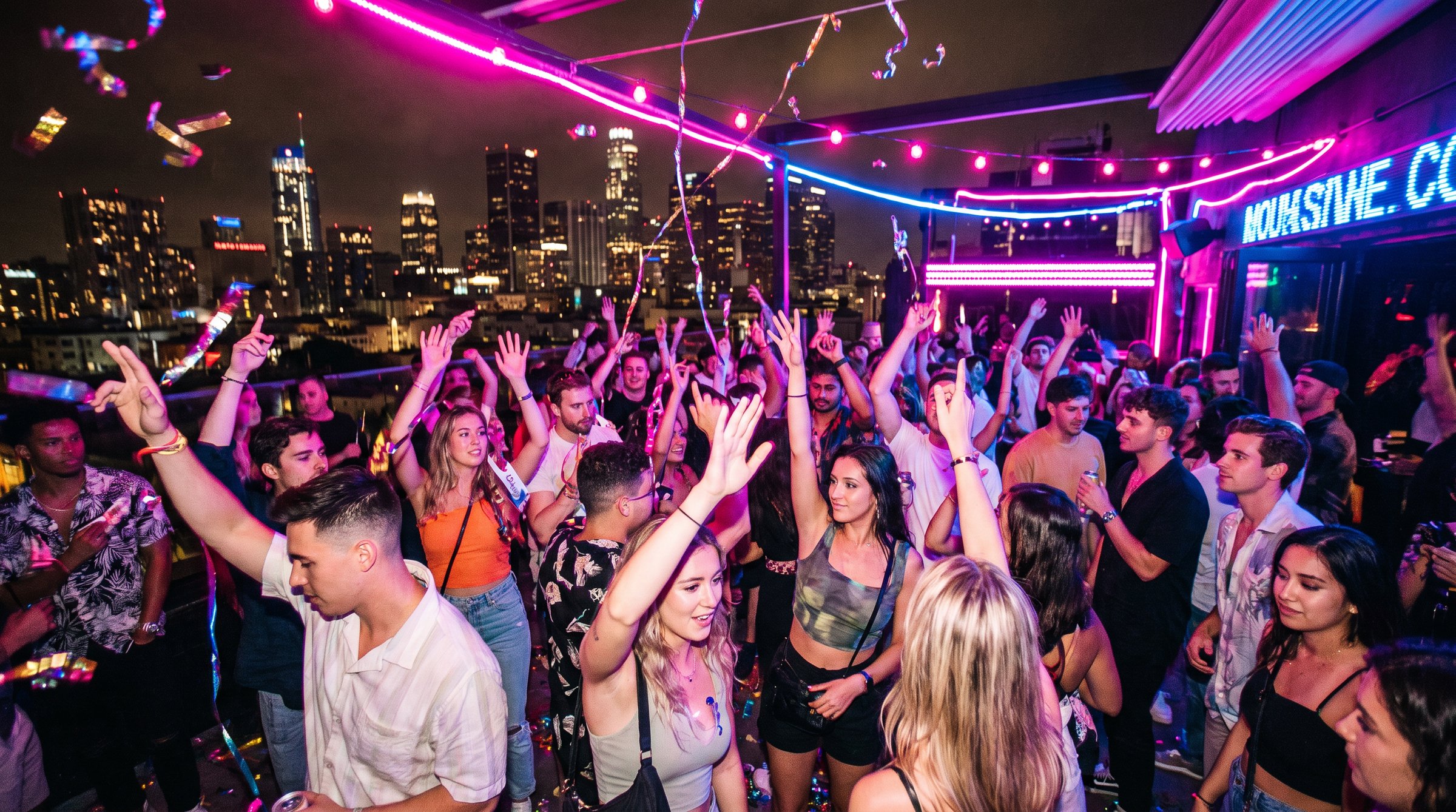A packed rooftop party at night
