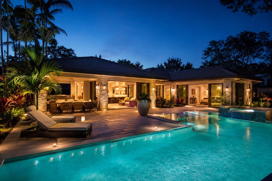 A lit pool at a modern vacation property in the evening